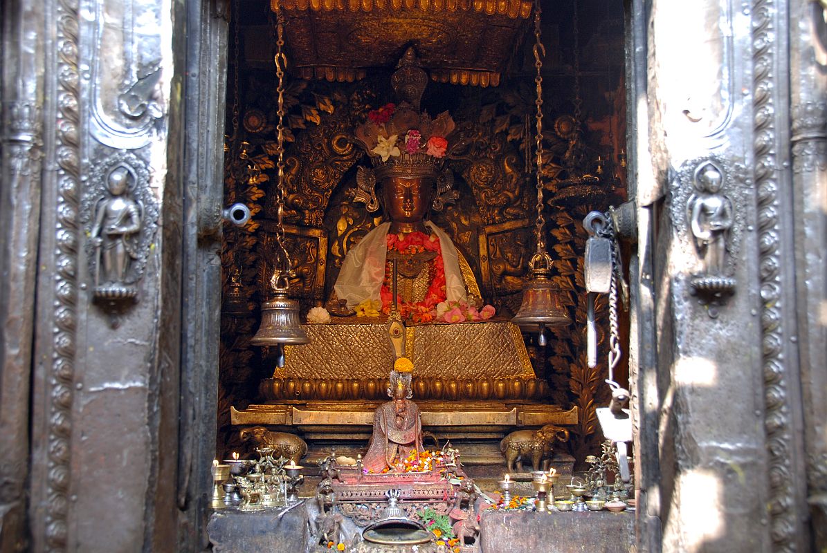 Kathmandu Patan Golden Temple 24 Shakyamuni Buddha In Main Temple An extremely ornate statue of Shakyamuni Buddha is the main image inside the main shrine of the Golden Temple in Patan. The two bells hanging from the ceiling in the front of the Buddha are used to perform daily worship.